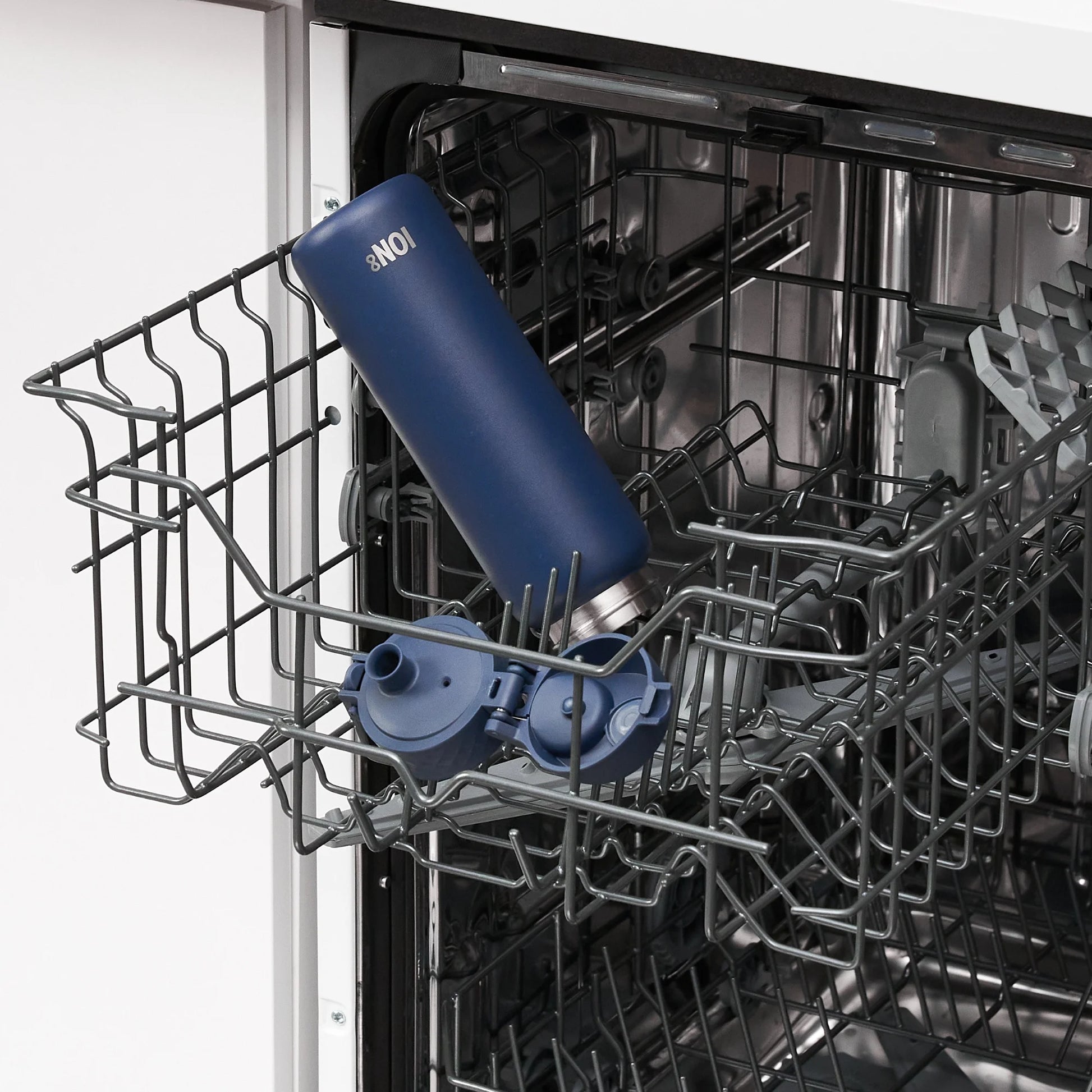 A blue water bottle with the text "ION8" placed on the top rack inside an open dishwasher in a kitchen setting.