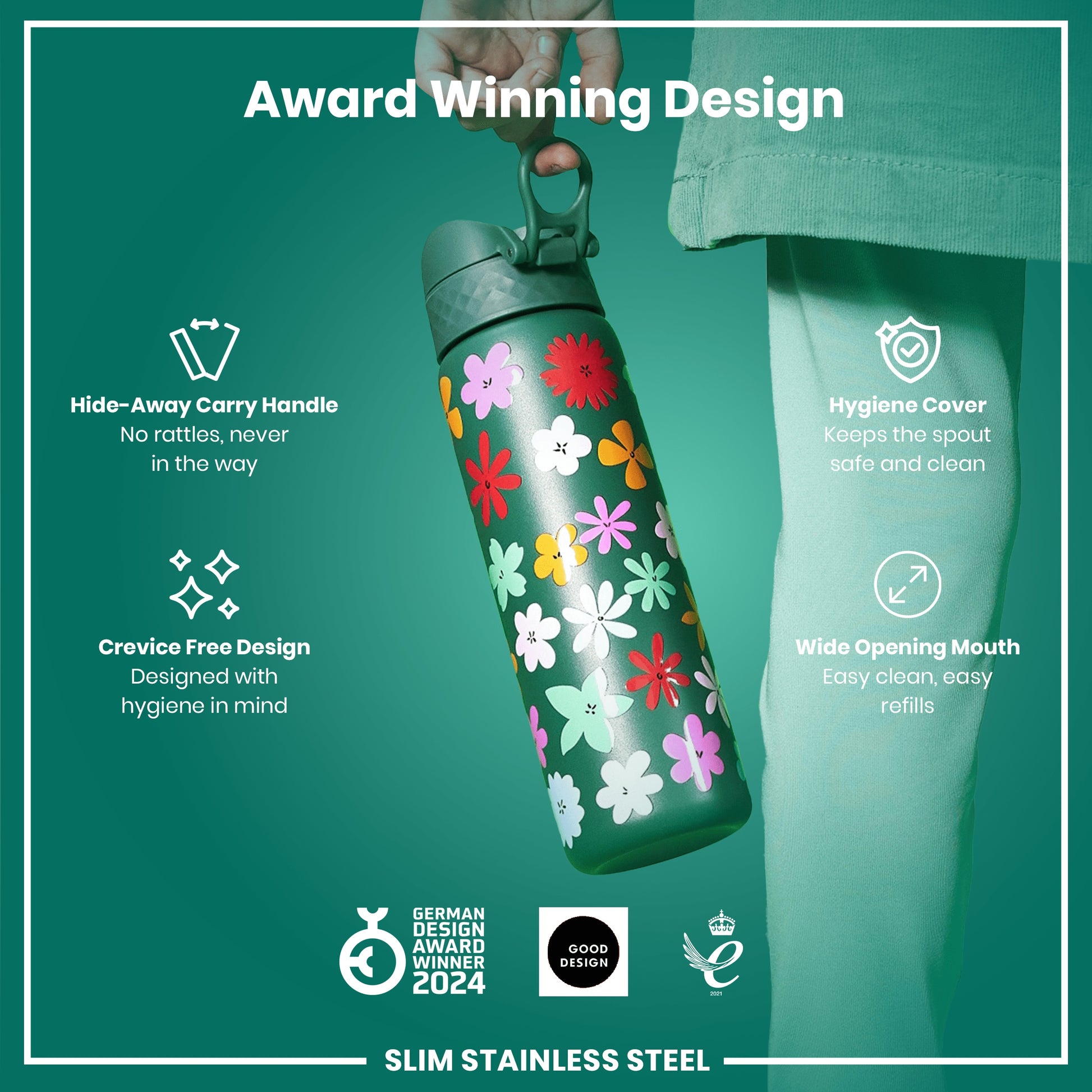 A slim stainless steel water bottle, being held, features a floral design. It has a hide-away handle, crevice-free design, hygiene cover, and wide opening mouth. The bottle is an award-winning design.