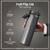 A dark gray stainless steel water bottle with a full flip lid is held by a hand. The lid opens 240 degrees. The bottle is shown against a gray background. 