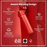 A red, double-walled stainless steel water bottle is held by a hand against a red background. Its features include a hide-away handle, crevice-free design, hygiene cover, and wide opening mouth. The bottle is a 2024 German Design Award winner.
