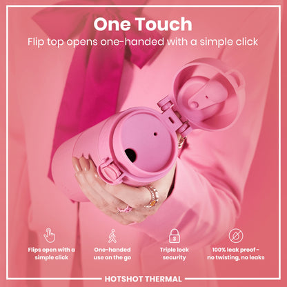 A pink thermos is held; its flip top opens with a single click. The context is a pink background and a person wearing a pink jacket. One Touch. Flips open with a simple click. One-handed use on the go. Triple lock security. 100% leak proof - no twisting, no leaks. HOTSHOT THERMAL.