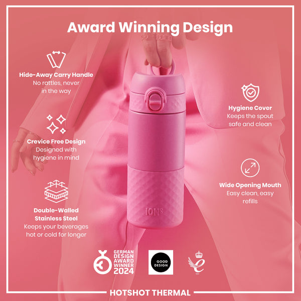 A pink, double-walled stainless steel water bottle is being held; it features a hide-away handle, crevice-free design, hygiene cover, and wide opening mouth. The bottle is award-winning.