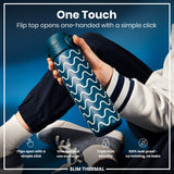 A teal water bottle with a wavy design is held; its flip top opens one-handed. The context is a person wearing casual clothes against a blue background. One Touch. Flip top opens one-handed with a simple click. Flips open with a simple click. One-handed use on the go. Triple lock security. 100% leak proof - no twisting, no leaks. SLIM THERMAL.