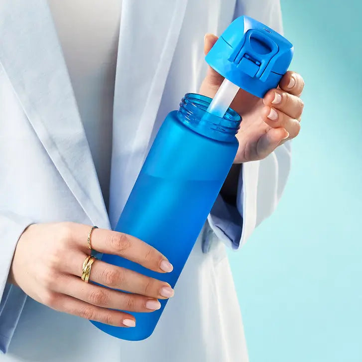 A person holds a blue water bottle, opening the lid to insert a straw. The context is a light blue background.