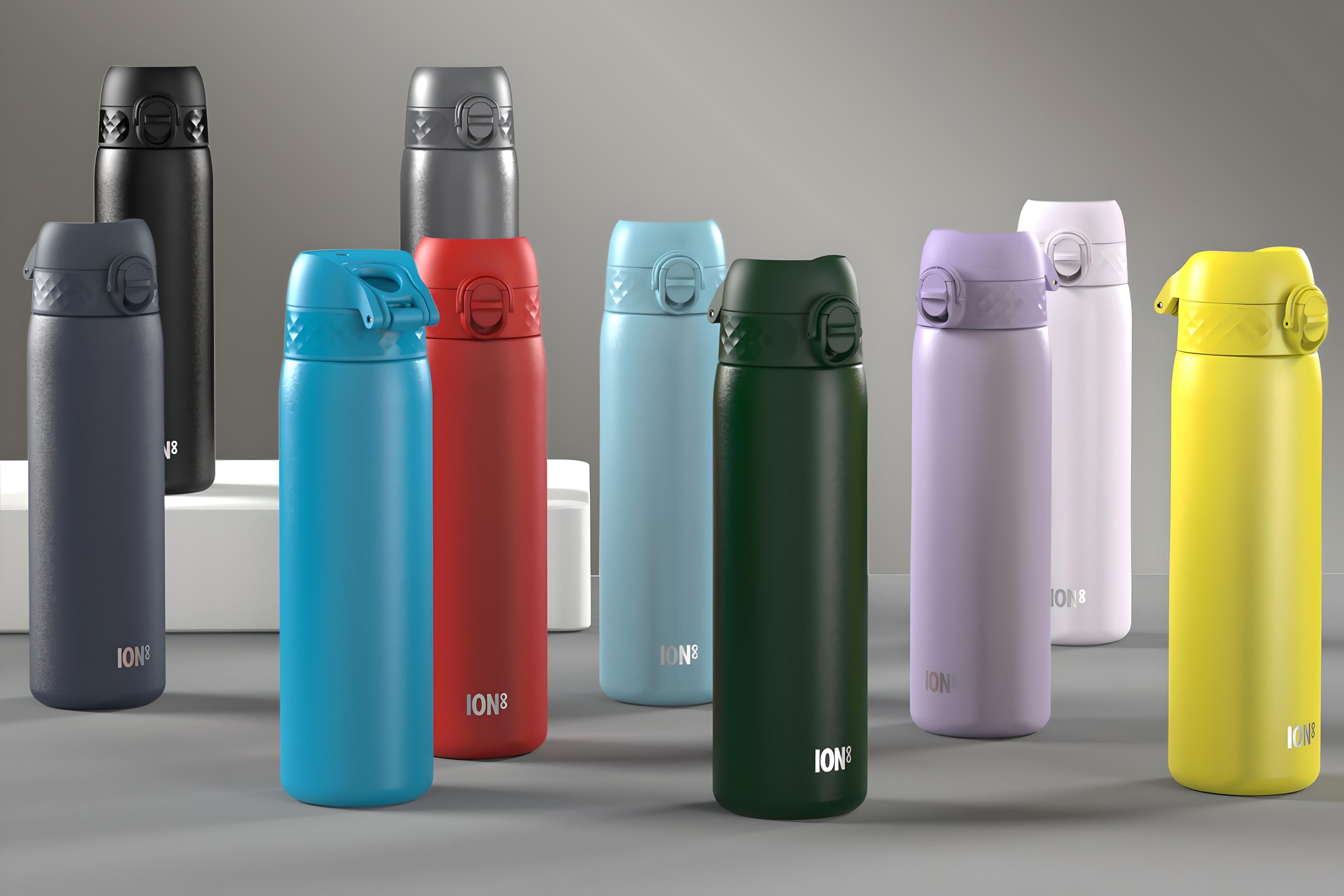 Several ION8 water bottles, in various colors, are displayed on a gray surface. They are standing upright, showcasing their designs. The bottles are arranged in an aesthetically pleasing manner.