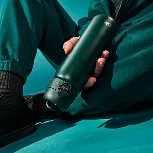 steel green water bottle being held upside down to show leak proof